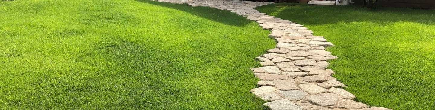 起伏のある芝張りと自然石の園路